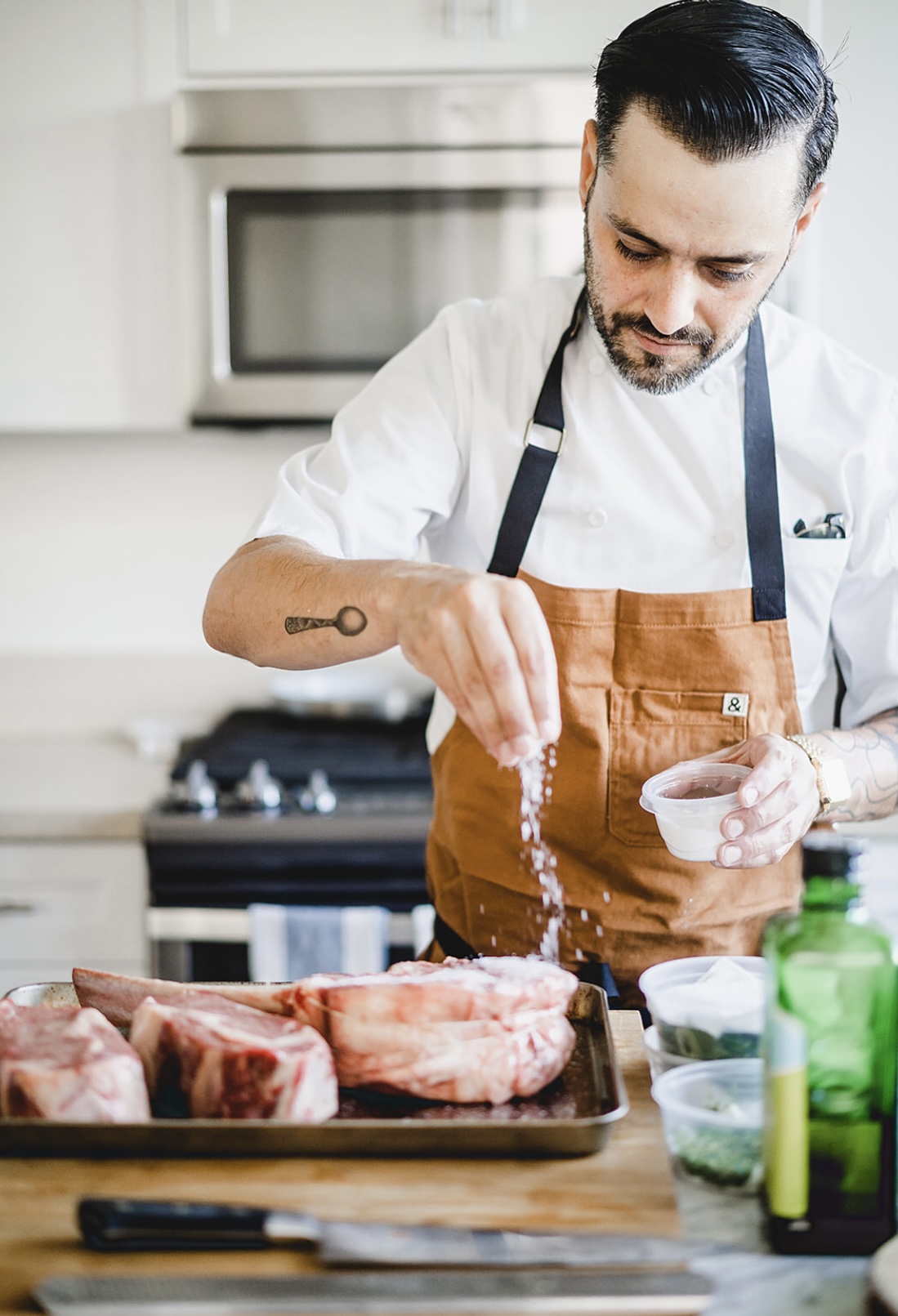 Chef Justin Campbell seasoning ingredients in a private kitchen